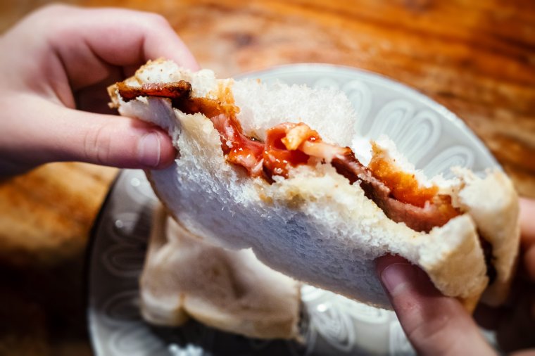 Close-up of child holding a bacon sandwich