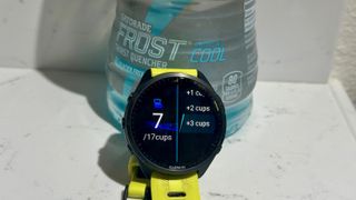 The Garmin Forerunner 965 shows the hydration tracking data app sitting in front of a bottle of Gatorade.